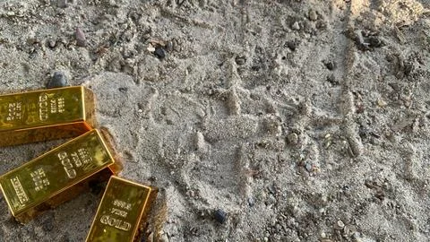 View of gold bars and sandy soil background Stock Photos
