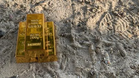 View of gold bars and sandy soil background Stock Photos