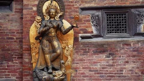 View of a golden deity statue against a brick wall, Nepal. Vídeo Stock 335607135