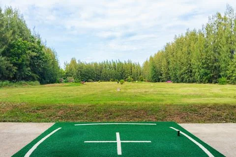 View of the golf driving range with grassy slopes and distance signs with a.. Stock Photos