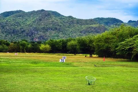View of golf driving range with grassy slopes and distance signs with beaut.. 写真素材