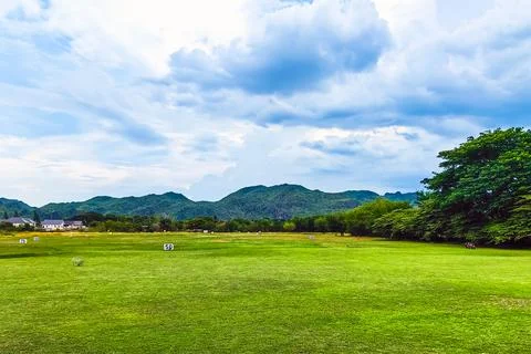 View of golf driving range with grassy slopes and distance signs with beaut.. Stock-Fotos