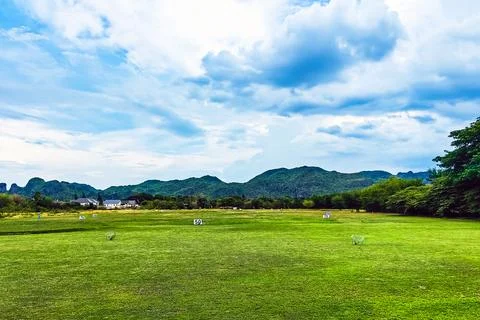 View of golf driving range with grassy slopes and distance signs with beaut.. 写真素材