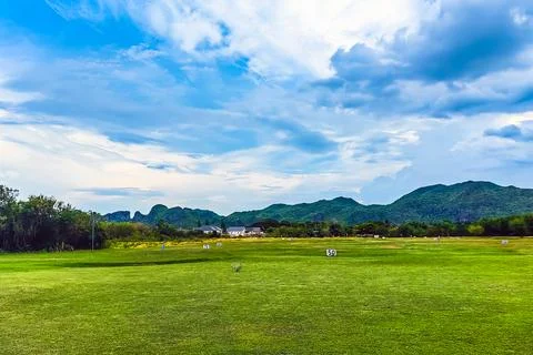 View of golf driving range with grassy slopes and distance signs with beaut.. 写真素材