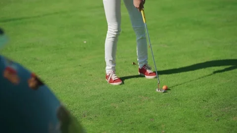 View of a golfer hitting the ball with a golf club from behind a golf car. Stock Footage 218994859