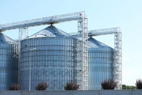 View of grain elevator against blue sky on sunny day. Cereal farming Fotos de archivo
