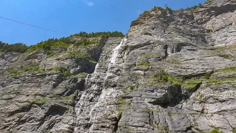 View of the great waterfall in the mountain in Swiss alps Stock Footage 240090814