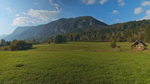 View of green field and alpine valley on sunny day Stock Footage 119756833