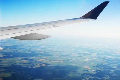 View of the green fields and clouds from within, out of the plane Stock Photos