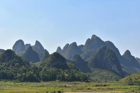 View of green fields and Karst mountains under a blue sky in Yangshuo, China Stock-Fotos