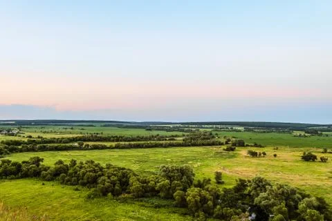 View of green forest-steppe plain. Flatland valley in evening time. Stock Photos