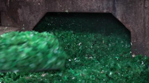 View of green glass shards being shoveled into a chute, Bangladesh. Stockbeeldmateriaal 336411904