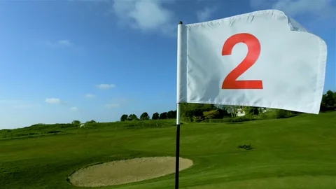 View of a green golf course, hole and flag on a bright sunny day. Sport, relax Stock Footage 75634755