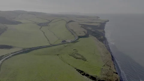 A view of a green hillside with a road running down it Stock Footage 298280495