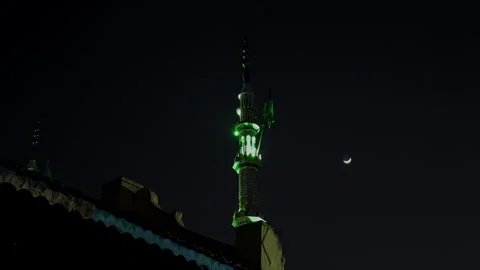 View of green laser beams lighting night sky above mosque with half moon gl.. Stock Footage 335872561