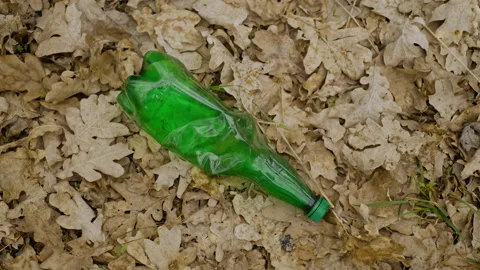 View of a green plastic bottle on the ground, environment pollution concept Stock Footage 157257962