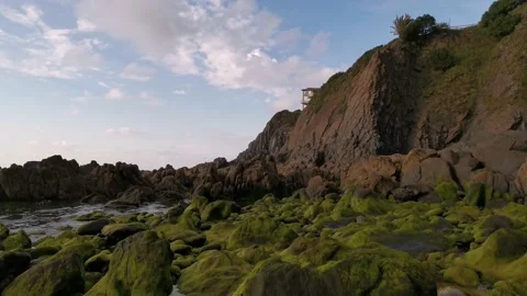 View of the green rocks and cliffs from the beach Stock Footage 131838011
