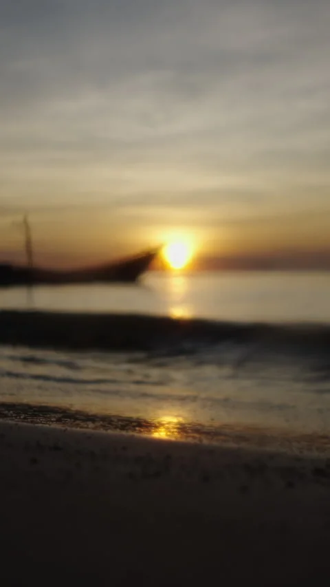 View from the ground of the sea waves on the shore with a boat in the background Video stock 265496033