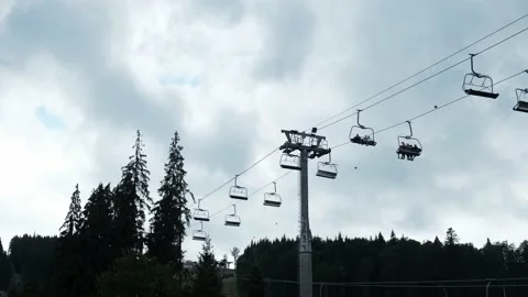 View from the ground at a ski lift in the summer. Overcast gray cloudy sky Stock Footage 148652699