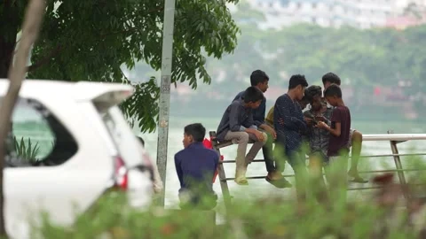View of a group of young men sitting by the water in Dhaka, Bangladesh. Video stock 335554860