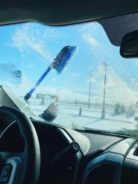 View of guy cleaning off the snow from front window Stock Photos