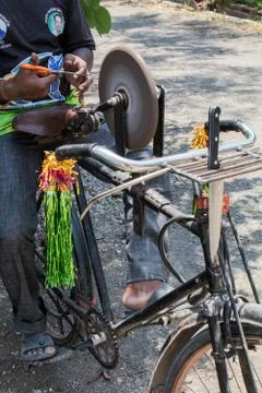View of a guy sharpening tools on his bicycle Stock Photos