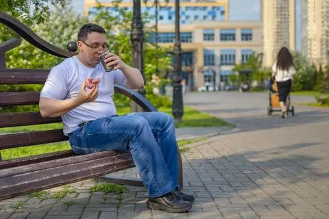 View of guy who casually drinks coffee, tea, drink, cocoa with a bun, donut Stock Photos