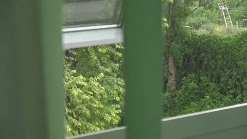 View from the half-open window through the developing blinds to rain and wind Stock Footage 92201554