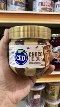 View of a hand holding a bottle, CED brand with chocolate peanut flavor Stock Photos