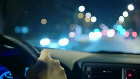 View of a hand holding the steering wheel of a car while driving at night. Stock-Footage 336265677
