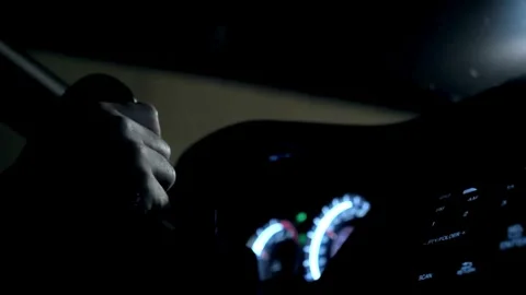 View of a hand holding the steering wheel of a car while driving at night. Stock-Footage 336265765