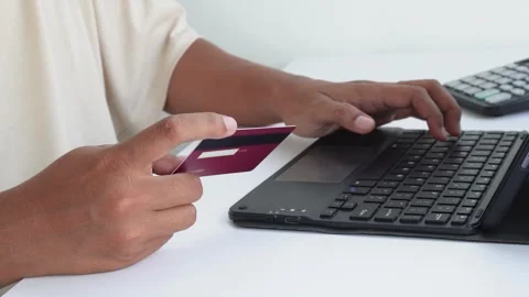 A view of a hand making a transaction with a credit card and a laptop. Video stock 338170070