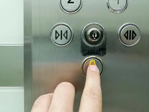 View of hand pressing emergency button on interior panel of an elevator Stock Photos