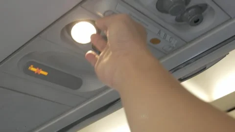 View to hand switch off personal light above seat on airplane, Comfort flig.. Stock Footage 314175887