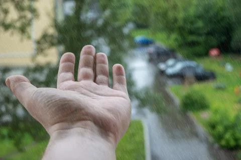 View of the hand from the window of the house during the rain Stock Photos