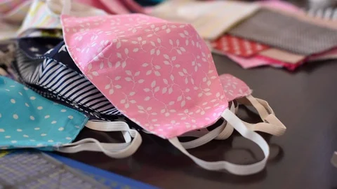 View on handmade fabric cotton face masks on a table with sewing accessories. Stock Footage 128207967
