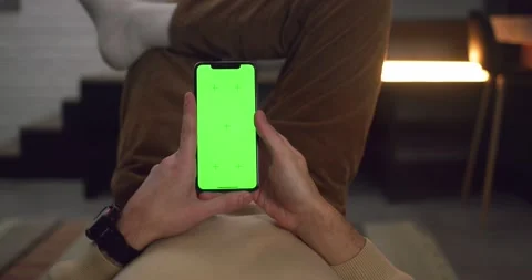 View on hands of Man holding Modern Smartphone with Green Screen. Resting at Stock Footage 166162778