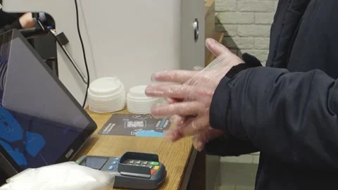 View of the hands of a man putting on in a store disposable gloves close up Stock Footage 150813127