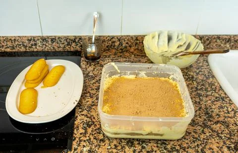 View of hands preparing the cream to make a Tiramisu cake in the kitchen at h Stock Photos