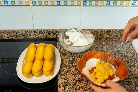 View of hands preparing the cream to make a Tiramisu cake in the kitchen at h Stock Photos