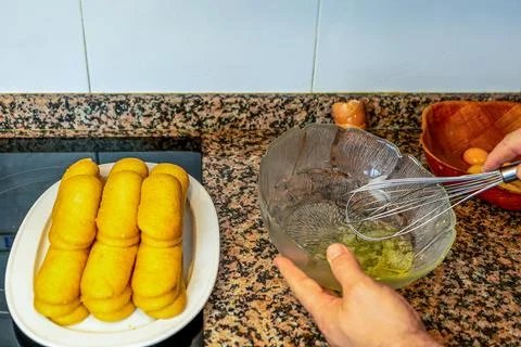 View of hands preparing the cream to make a Tiramisu cake in the kitchen at h Stock Photos