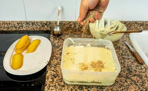 View of hands preparing the cream to make a Tiramisu cake in the kitchen at h Stock Photos
