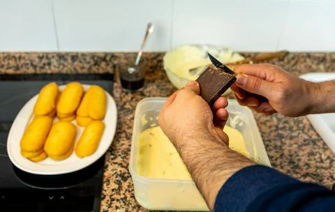 View of hands preparing the cream to make a Tiramisu cake in the kitchen at h Stock Photos