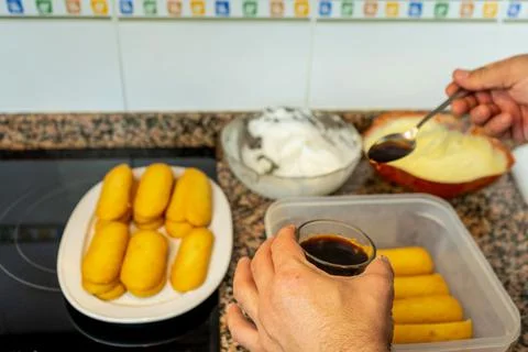 View of hands preparing the cream to make a Tiramisu cake in the kitchen at h Stock Photos