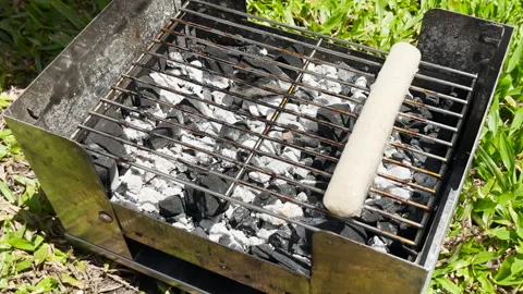 View of hands putting sausages on the grill with kitchen tongs Stock Footage 287952844