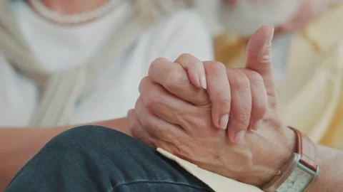 View of a hands senior couple holding hands while resting on a couch. Hugging Vídeos de archivo 224533809