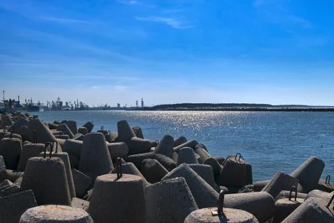 View of a harbor over modular concrete block ripraps in foreground and port in Stock Photos