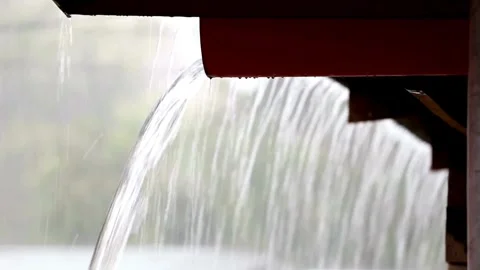 View of heavy rain water flowing down from the roof in rainy season. 4K HD Видео 336571401
