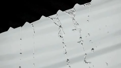 View of heavy rain water flowing down from the roof in rainy season. 4K HD Stock-Footage 336571428