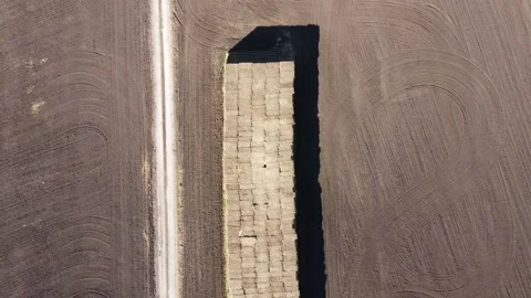 View from a height of folded bales of straw standing on a black field Stock Footage 162784608